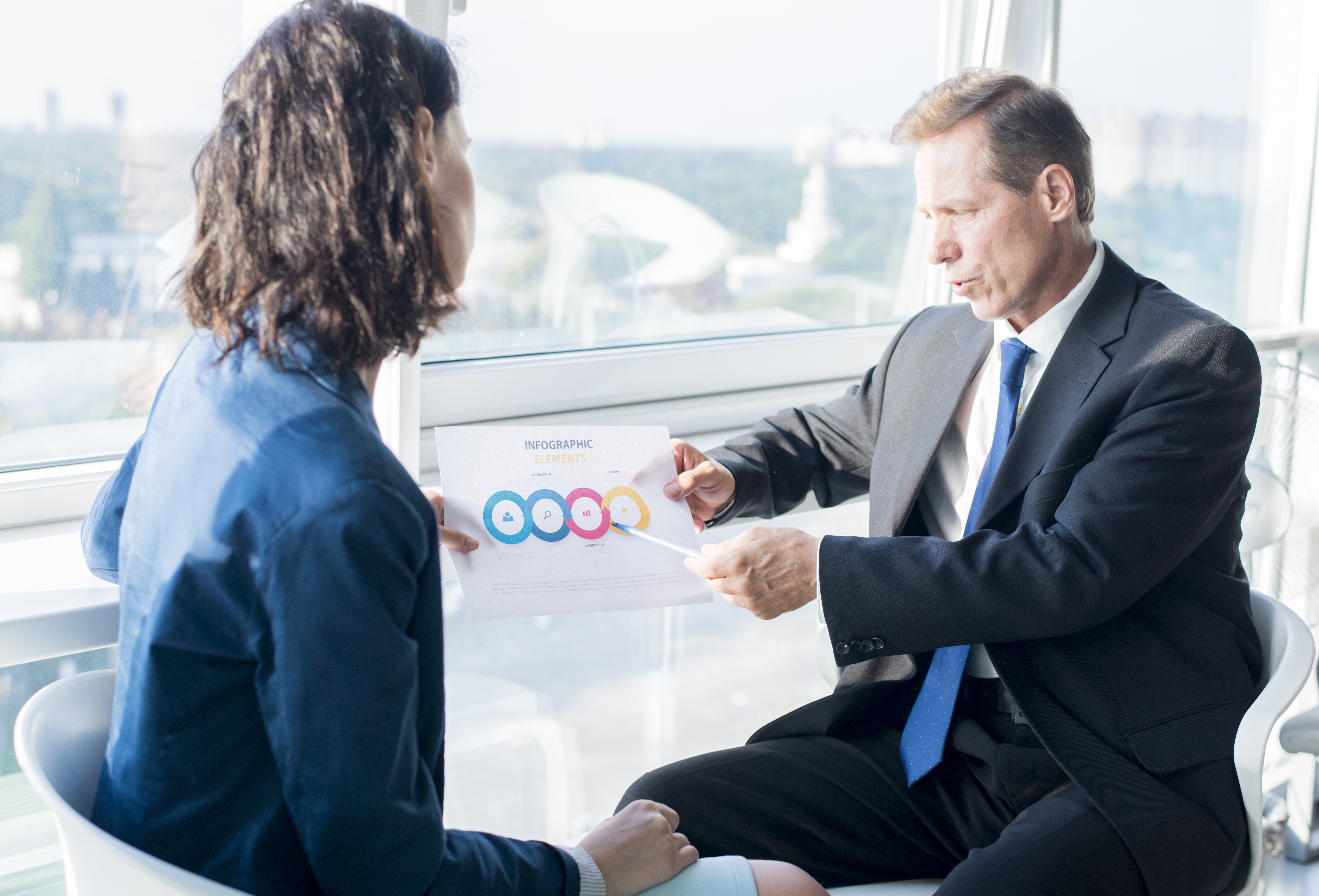 businessman-explaining-infographic-elements-sheet-his-female-colleague